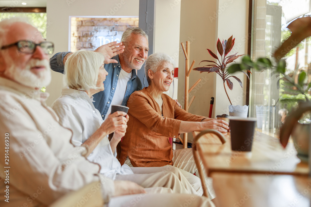 Cheerful senior people spending time together in cafe
