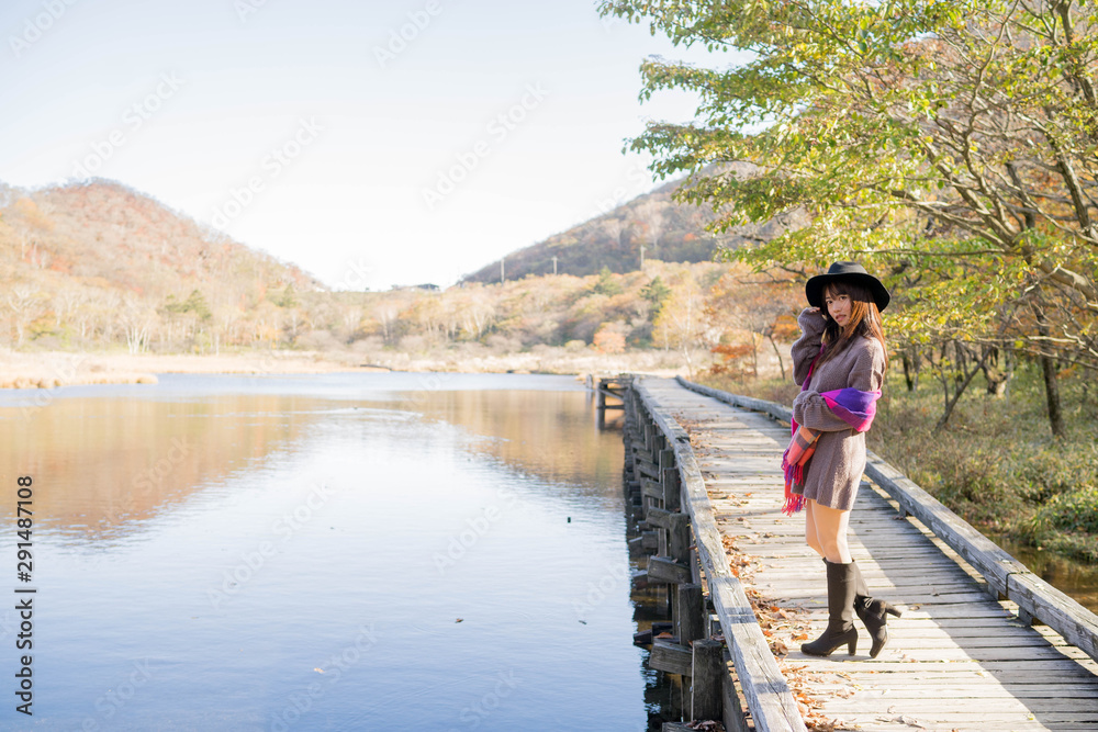 Naklejka premium 紅葉と湖と女性
