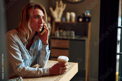 Woman with coffee talking on the phone stock photo