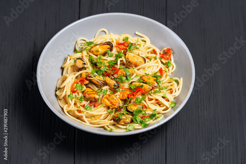 Pasta Spaghetti seafood with mussels Marinara, Typical dish of Italian pasta. top view. on a black background with a place for text, copy space
