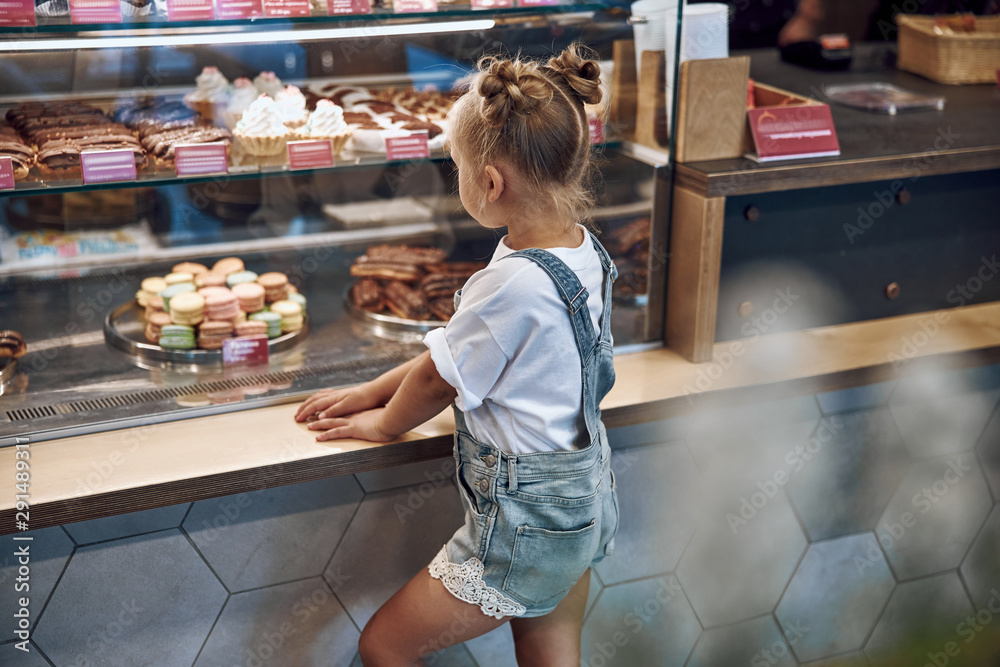 Girl looking at the sweet on display counter stock photo
