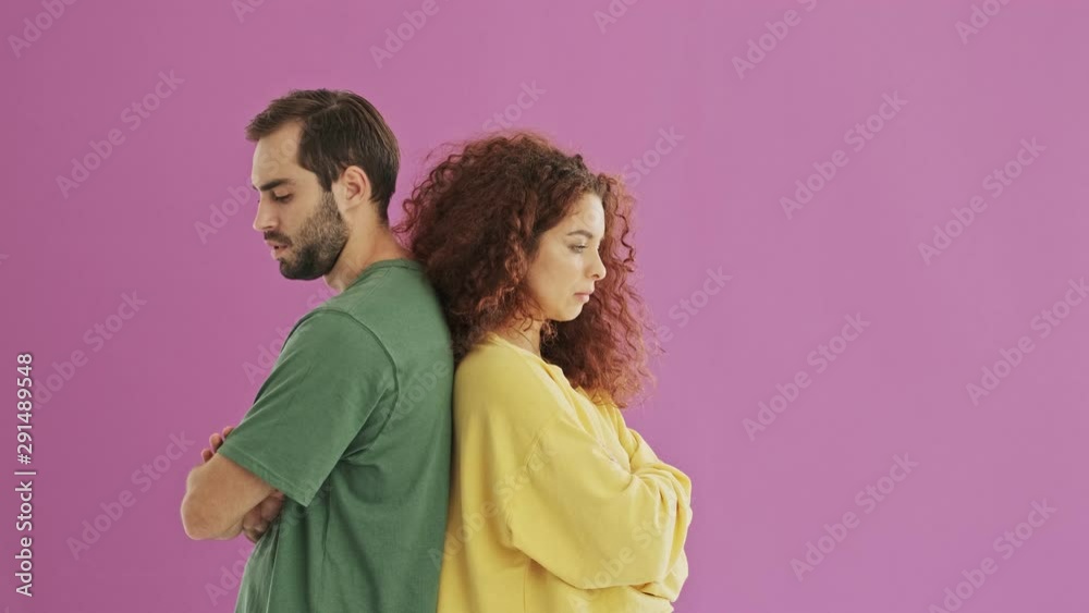 Upset young bearded brunet man turning around and hugging his girlfriend. Cute young redhead curly woman feeling upset at her boyfriend but forgiving and hugging him Upset young bearded brunet man turning around and hugging his girlfriend. Cute young redhead curly woman feeling upset at her boyfriend but forgiving and hugging him