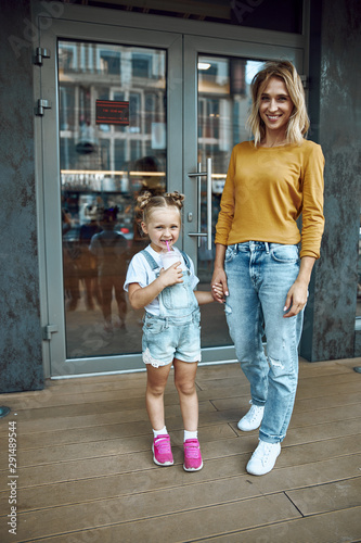 Mother and daughter standing outside the cafe stock photo