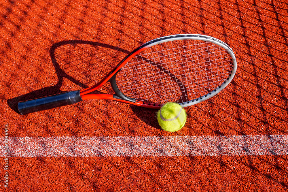 Tennis ball, racket and line on an outdoor court