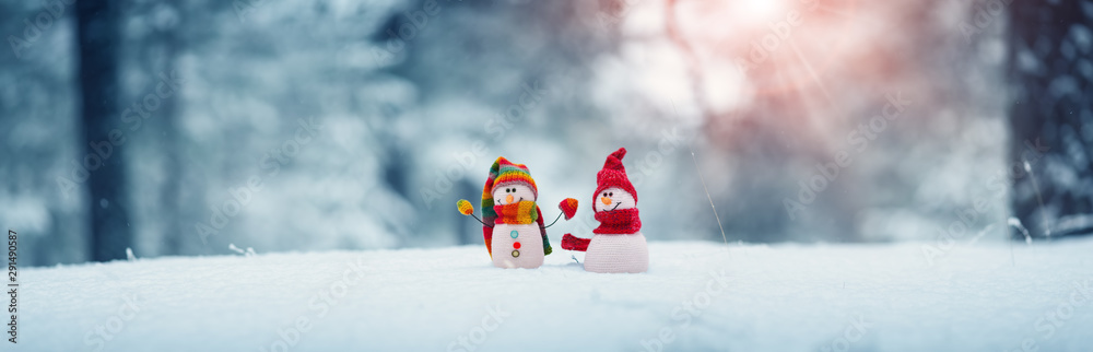 little snowmans on soft snow on blue background - obrazy, fototapety, plakaty 