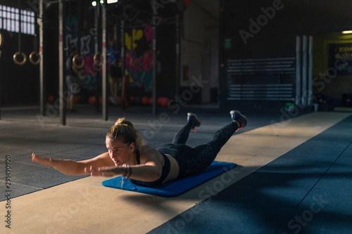 A blonde woman doing exercises at a gym