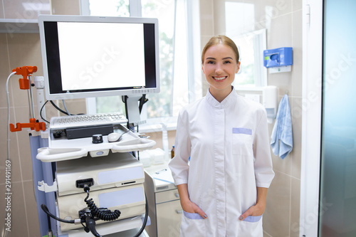 Cheerful doctor near digital equipment in hospital stock photo