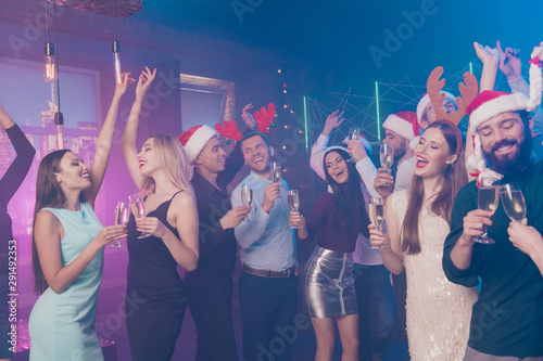 Portrait of nice-looking attractive glamorous gorgeous smart stylish cheerful cheery positive girls and guys having fun winter December tradition chill out in luxury place nightclub