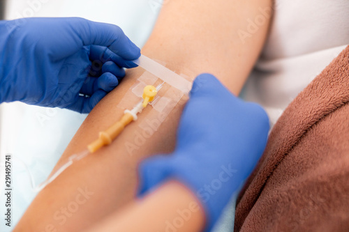 Close up of medic holding a band-aid near patient hand