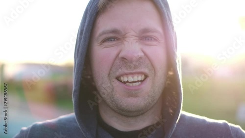 Healthy young caucasian man standing outdoors and smiling. It is cold outside and he exhales steam