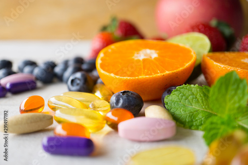 Obraz na płótnie Colorful pills and capsules with fresh fruits