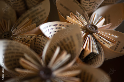 Stylish origami-type hand-made folded paper flowers constructed from buttons and pages from an old book