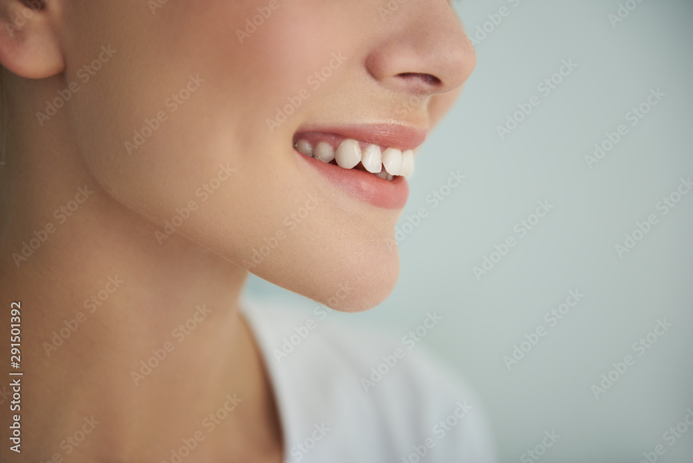 Obraz premium Young lady with perfect smooth skin smiling on light blue background