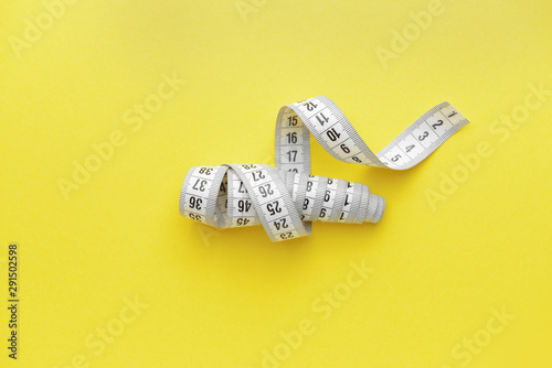 Measuring tape on color background