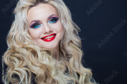 Portrait of a young luxurious blonde with long curls.