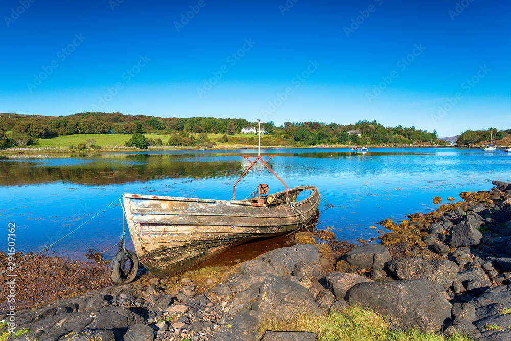 Deep blue sky over an old boat on the shore at Badachro