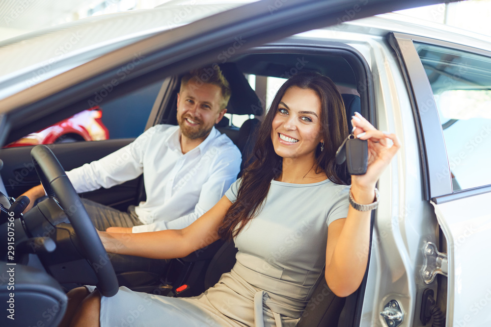 A happy couple bought a new car at a car showroom. A happy couple bought a new car at a car showroom.