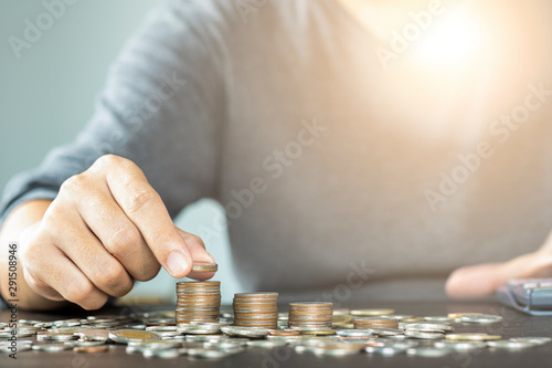 Man hand putting coins stacking for growth business and saving investment concept.