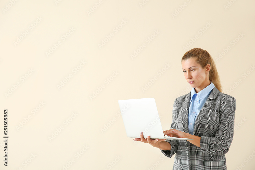 Beautiful young businesswoman with laptop on light background Beautiful young businesswoman with laptop on light background