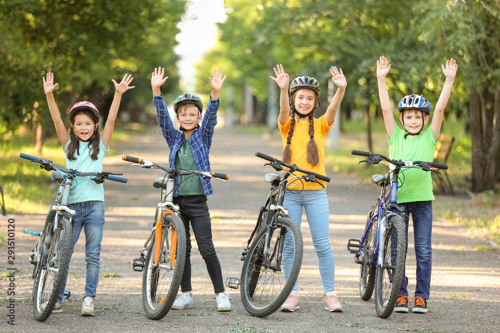 Cute children riding bicycles outdoors - obrazy, fototapety, plakaty 