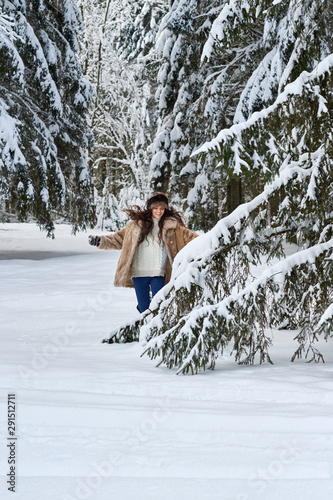 Girl runs through the snow in the woods.Caucasian girl