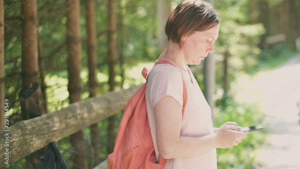 Female hitchhiker text messaging on mobile phone Female hitchhiker text messaging on mobile phone