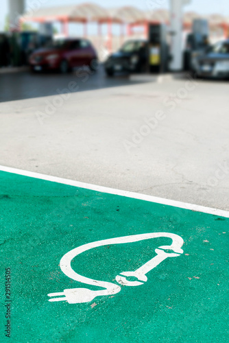 Car charging symbol painted on asphalt.