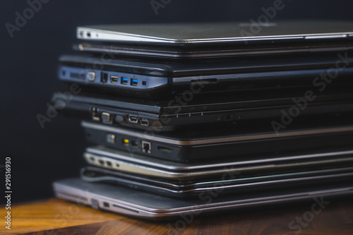 Stack of old laptops with dark background