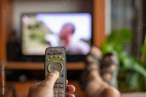 young man controlling the smart TV with a remote