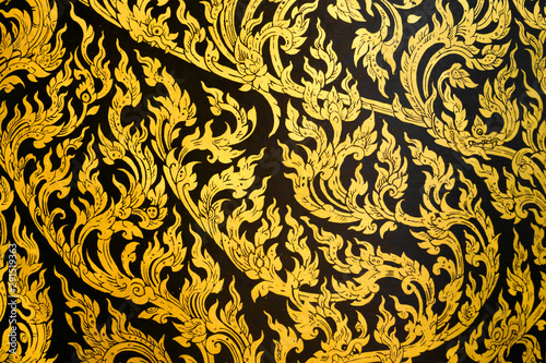 Thai traditional gorgeous pattern painting Lai Kanok sparkling golden exquisite tracery ancient beautiful art on black background interior decoration indoor at historical monument religious temple