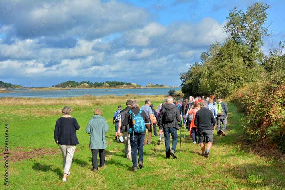 Groupe de randonneurs seniors sur un sentier de randonnée en Bretagne Groupe de randonneurs seniors sur un sentier de randonnée en Bretagne