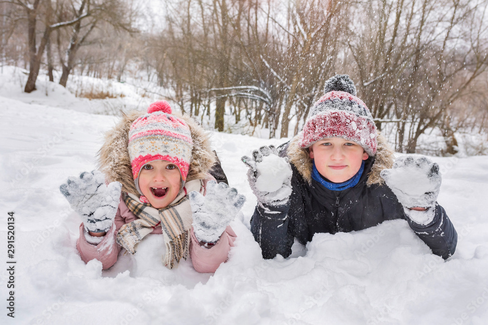  Happy kids have fun playing outdoors in winter. Winter vacation and holidays.