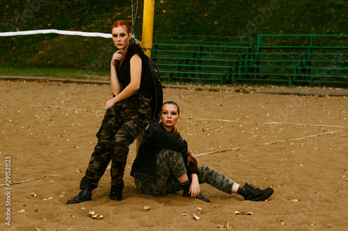 Two girls in military clothes and black t-shirts. Portrait. Patriotism. Army ammunition.