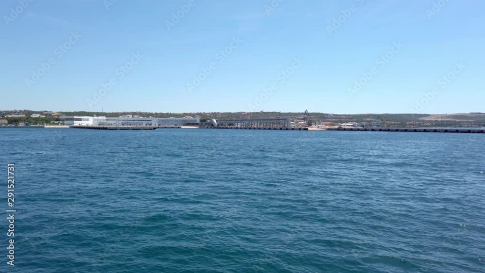 A view of the calm sea from the forward propelling ship/vessel/yatch showing deep blue waters and the seashore.Concept of transportation,export,import,travel.(1) A view of the calm sea from the forward propelling ship/vessel/yatch showing deep blue waters and the seashore.Concept of transportation,export,import,travel.(1)