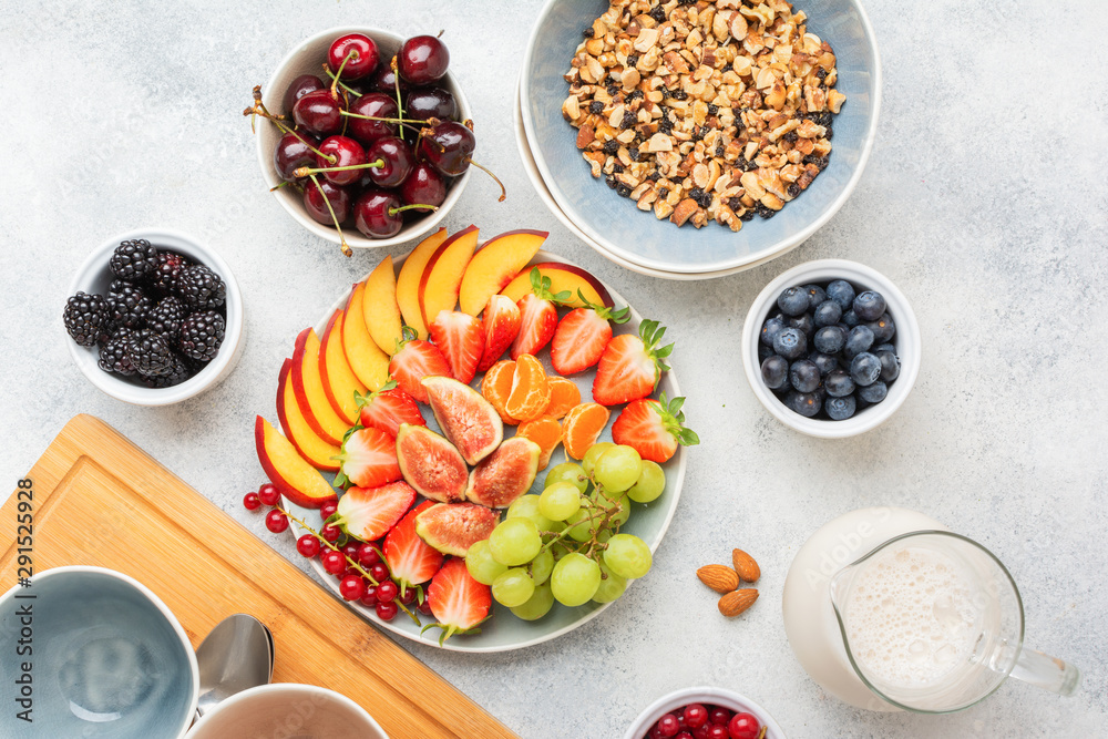 Raw vegan gluten free paleo granola or muesli made from nuts. Fruit berries platter, strawberries blueberries raspberries peach figs red currant, top view, selective focus Raw vegan gluten free paleo granola or muesli made from nuts. Fruit berries platter, strawberries blueberries raspberries peach figs red currant, top view, selective focus