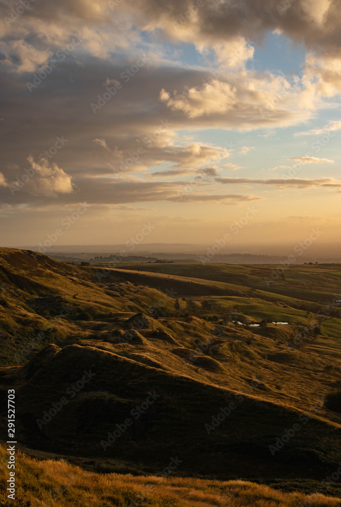 The view over the peak district and Manchester at sunset from the top of Coombe's Edge