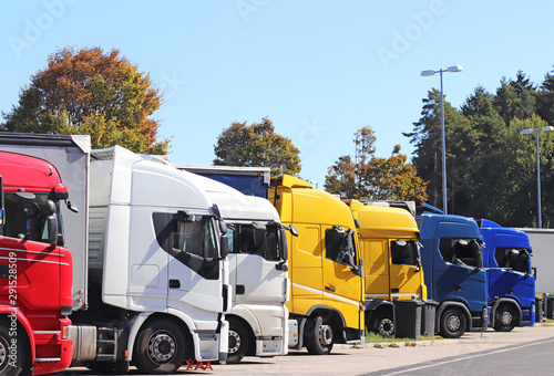 multi colored row of trucks parking on a highway service station