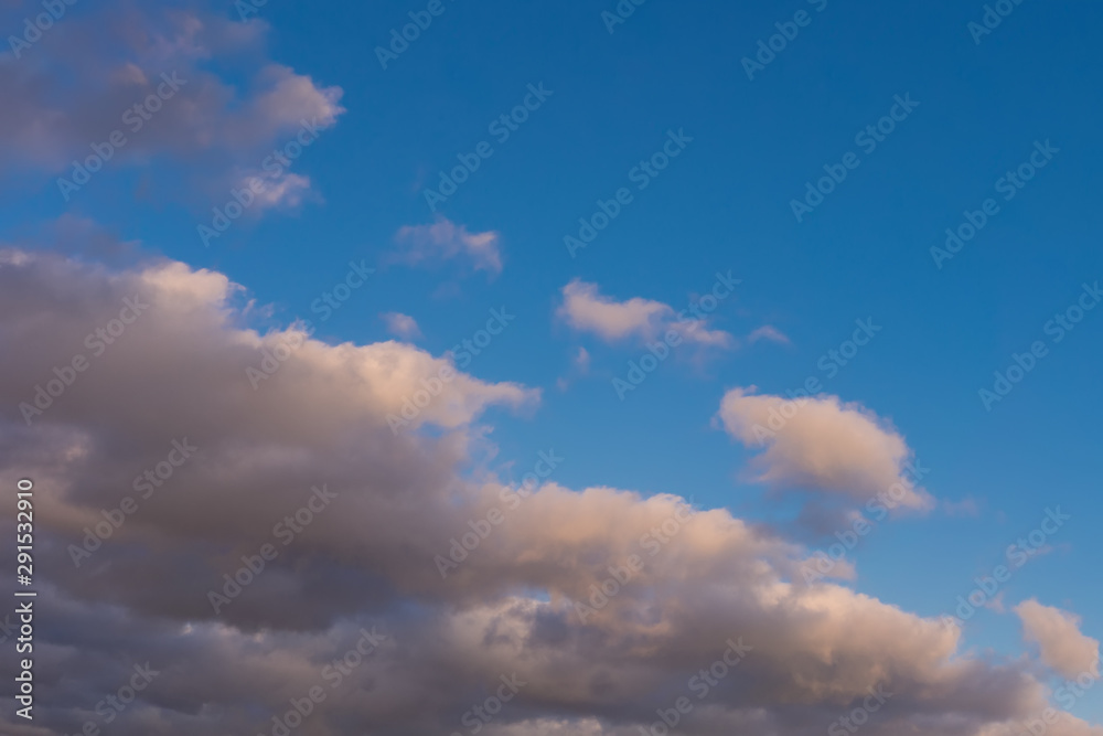 blue sky background with dark fluffy clouds
