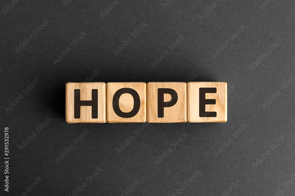 Obraz premium Hope - word from wooden blocks with letters, a feeling of trust hope concept, top view on grey background