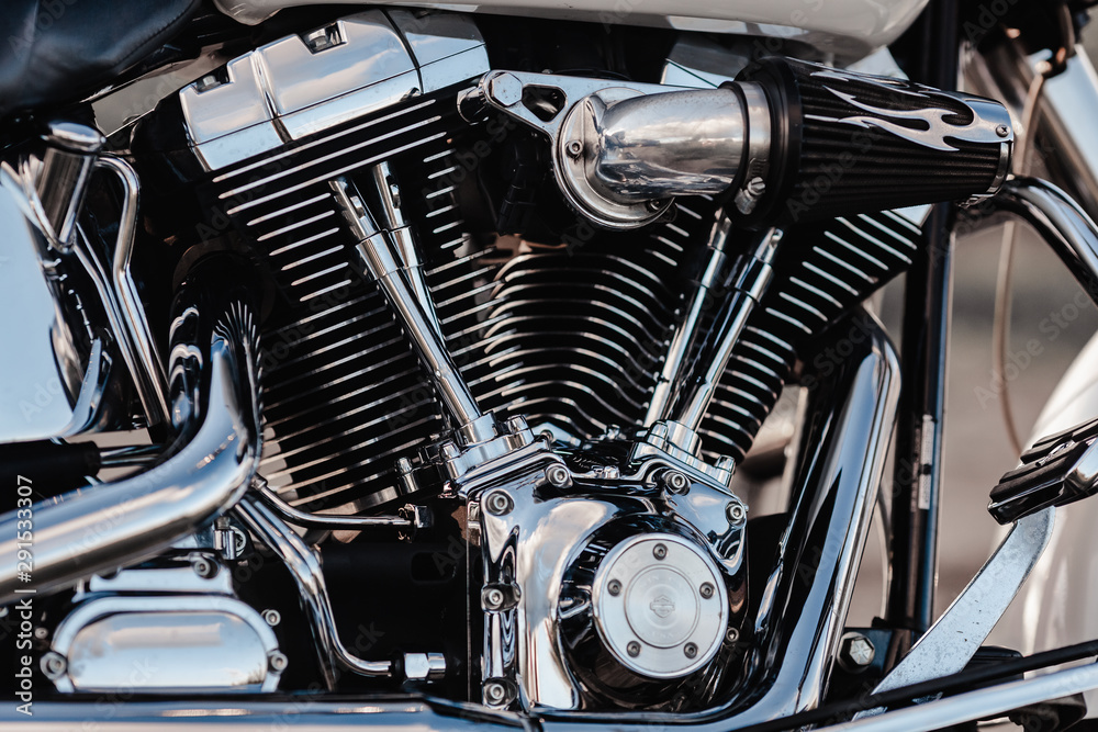 Rivne, Ukraine - September 23, 2019: Harley-Davidson Fat Boy motorcycle detail. Motorcycle engine exhaust pipes. Close up of a classic motorcycle with lots of chrome details. Rivne, Ukraine - September 23, 2019: Harley-Davidson Fat Boy motorcycle detail. Motorcycle engine exhaust pipes. Close up of a classic motorcycle with lots of chrome details.