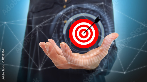 Businesswoman on blurred background using digital target and arrow photo