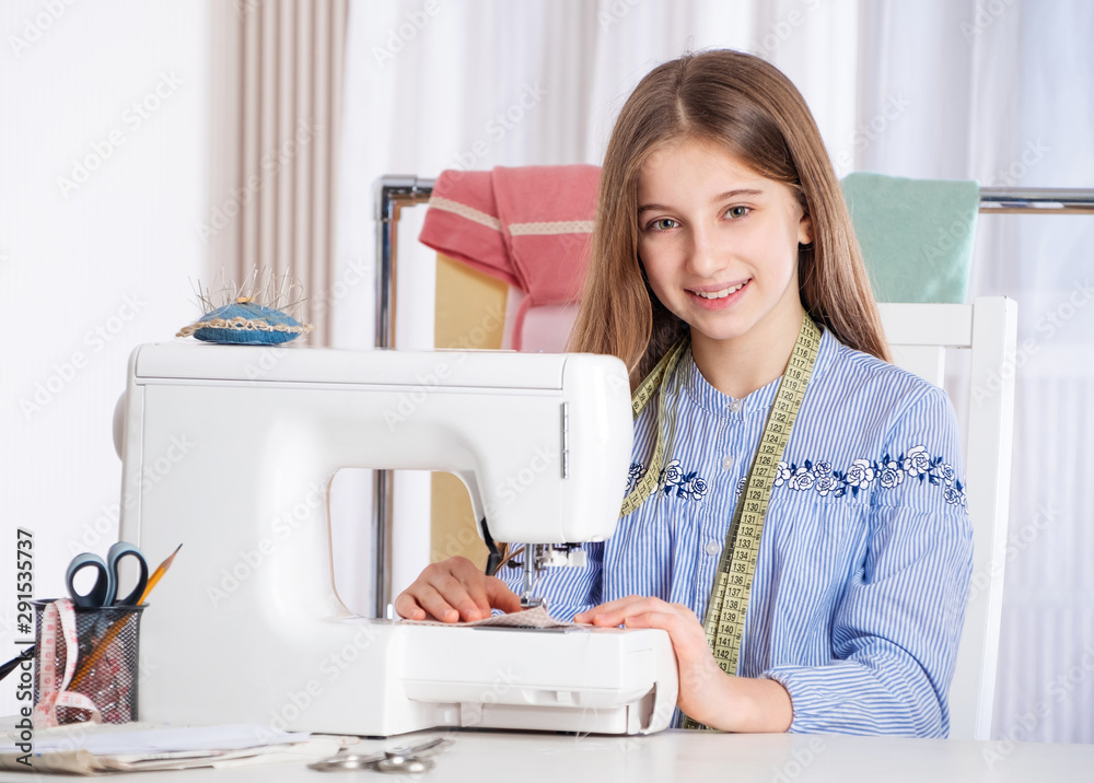 Teenager girl working with sewing machine as a tailor