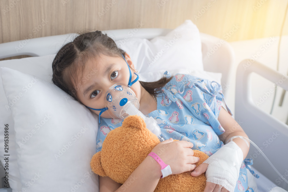 Patient Girl use inhalation with Nebulizer mask at hospital's bed Patient Girl use inhalation with Nebulizer mask at hospital's bed