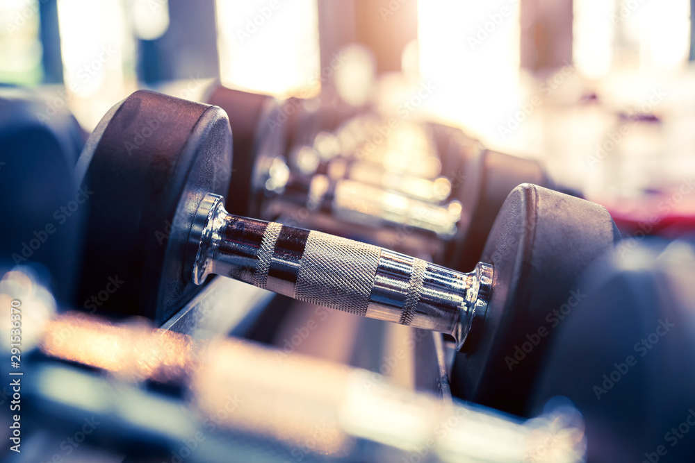 Close up many metal dumbbells on rack in sport fitness gym center.Weight Training Equipment concept. Close up many metal dumbbells on rack in sport fitness gym center.Weight Training Equipment concept.