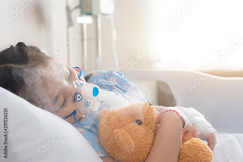 Patient Girl use inhalation with Nebulizer mask at hospital's bed