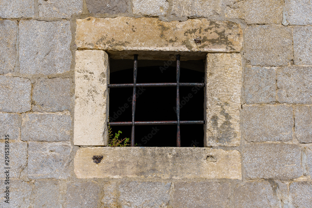 window of a building with bars in the medieval fortress