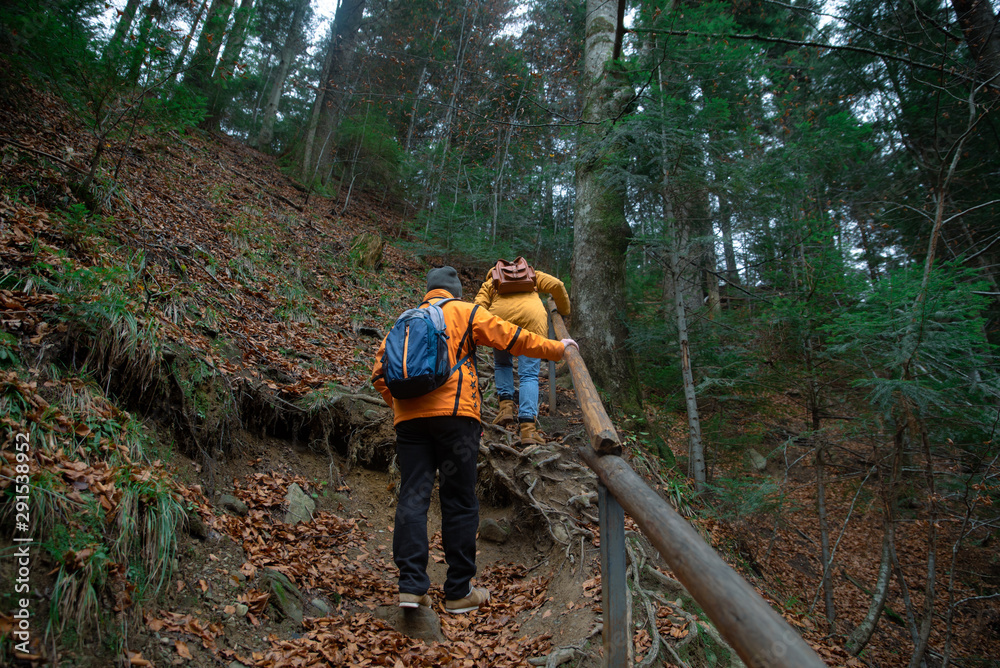 Fototapeta premium couple friends hiking by forest mountains