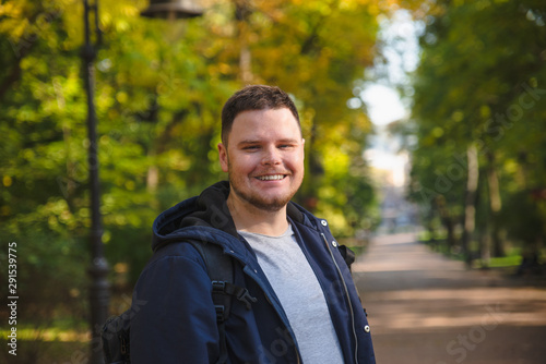 young smiling man portrait at city autumn park