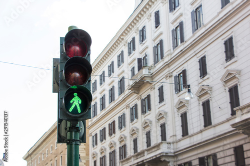 Green traffic light with colonial style building in background somewhere in Europe