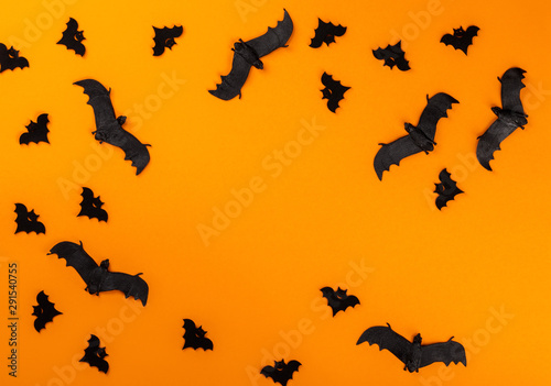 Halloween postcard. Тraditional festival of autumn. Decoration and party concept .Bats on a orange background .Flat lay, top view, copy space